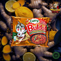 Kreative Darstellung eines Buldak Curry Ramen Pakets, umgeben von Curryzutaten wie Kurkuma, Zitronen und Ingwer. Die Szene spielt in einer Gewürzwelt, die die intensiven Aromen und die Schärfe des Curry-Ramen hervorhebt.